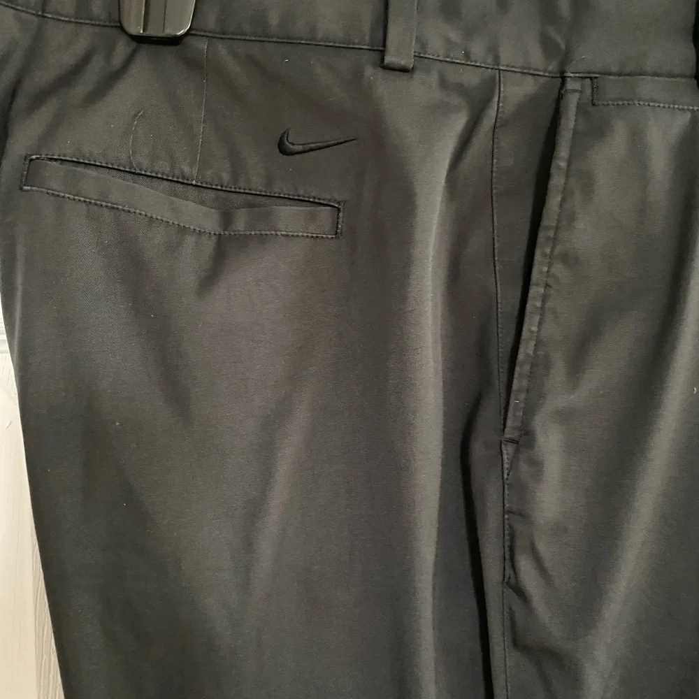 Nike Golf Tour Performance Dri-Fit black golf pants. Flat front Nike logo 40/26
